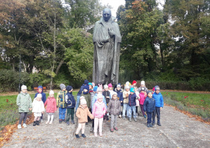Przedszkolaki w parku, w tle widać pomnik Stanisława Staszica